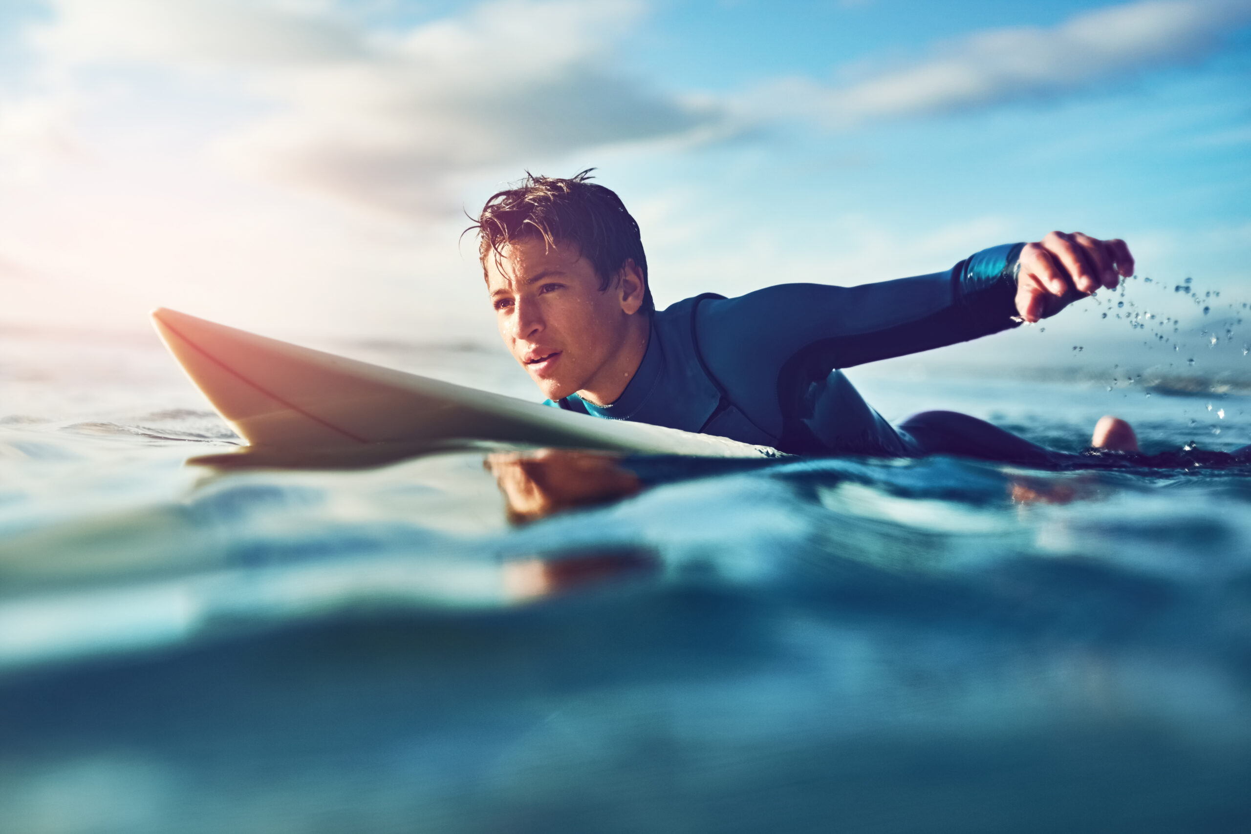 teen boy on surfboard in water
