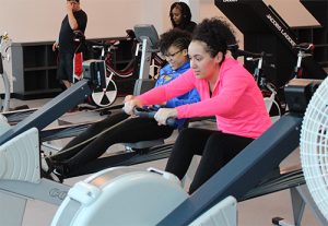 Two youth participants try the gym equipment at the 2017 Playmakers Program.
